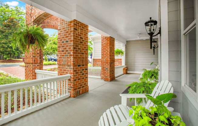an inviting front porch with rocking chairs at Seasons at Umstead apartments in Raleigh