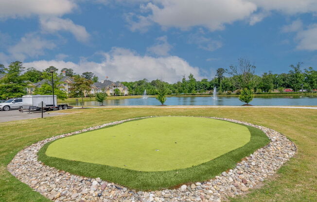 putting green with the pond in the background at Fenwyck Manor Apartments for rent