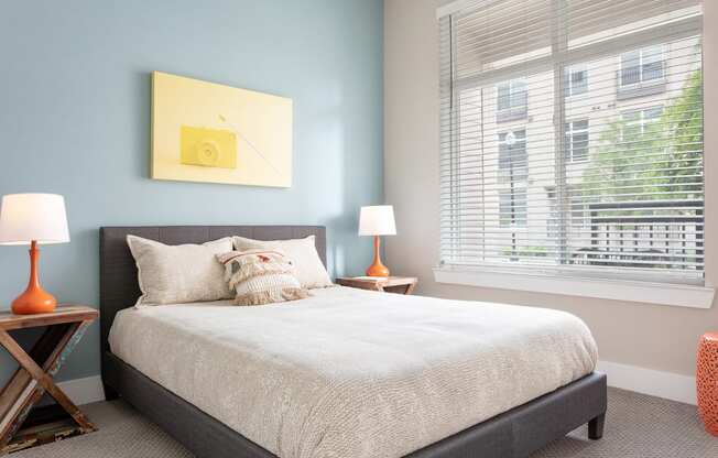 a bedroom with a bed and a large window