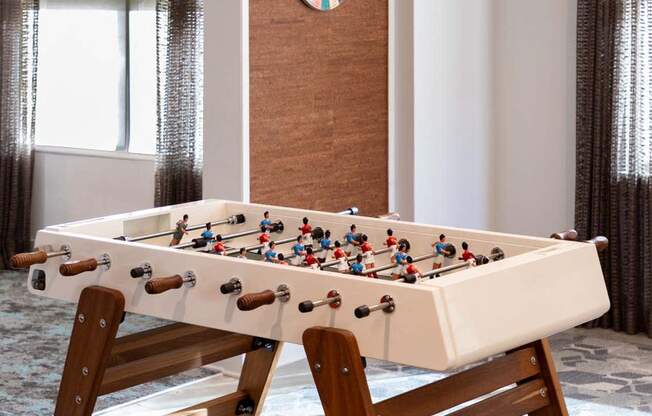 a foosball table in a living room with a dart board