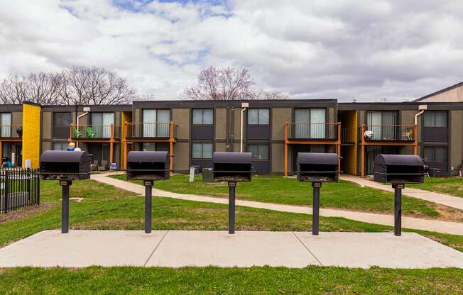 A series of mailboxes in front of apartment buildings.