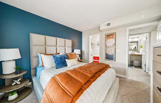 A bedroom with a large bed and a blue wall.