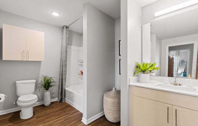 A white toilet sits next to a white sink in a small bathroom.