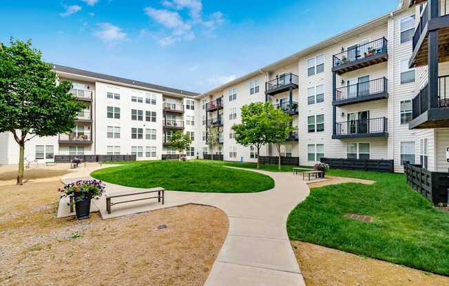 A sunny day at a residential complex with a walkway and green grass.