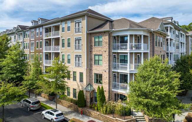 A large apartment complex with a parking lot in front.
