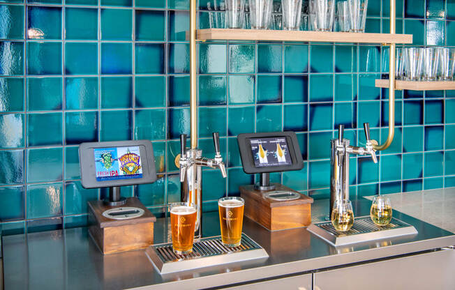 a bar with two pitchers of beer on a counter with blue tiles