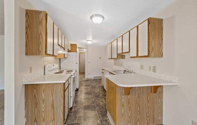 a kitchen with wood cabinets and white counter tops