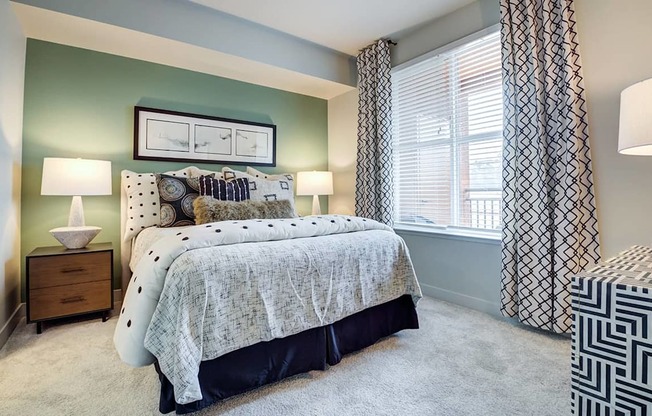 A bedroom with a bed, nightstand, and lamp.