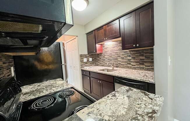 a kitchen with granite countertops and black appliances