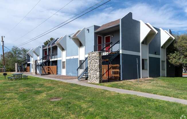 A modern house with a red door and a stone staircase.