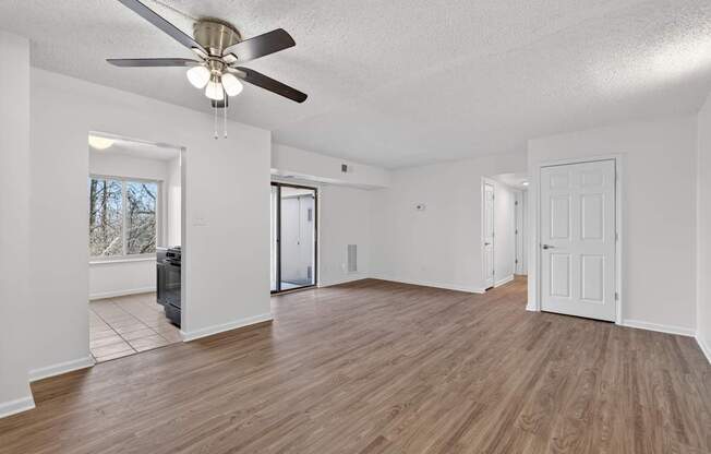 A room with a ceiling fan and wooden flooring.
