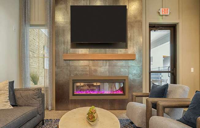 A living room with a fireplace and a flat screen TV mounted above it.