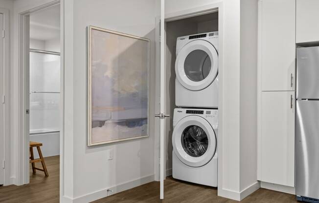 a white washer and dryer in a closet with a doorat Westbury Apartments, Rancho Cucamonga, CA