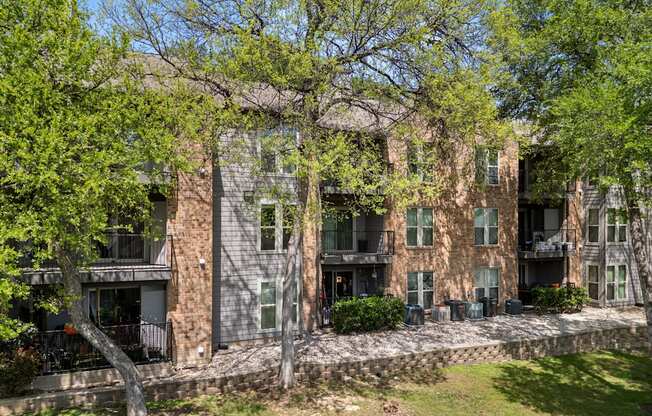 A large building with a balcony and a tree in front of it. at Montecito, Texas, 78741