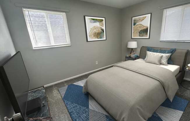 A bedroom with a bed, a television, and two pictures on the wall.