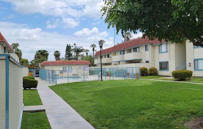 View of swimming pool & spa, wonderful trees and blue sky at Magnolia Apartments in Riverside, California.