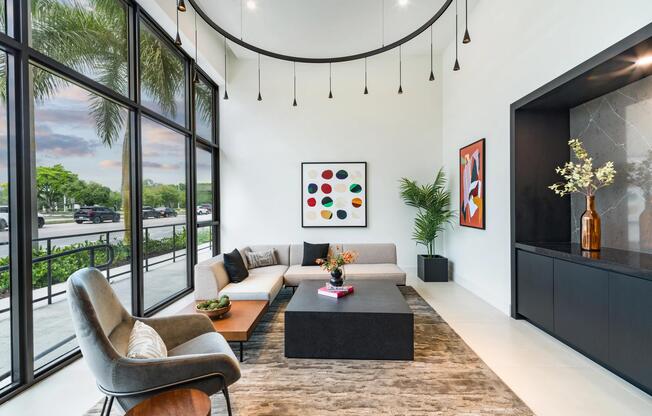 Double-height lobby lounge with floor-to-ceiling windows, curated seating, and sculptural lighting creating a bright, welcoming space to gather or unwind.