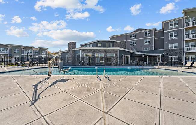 a swimming pool with an apartment building in the background