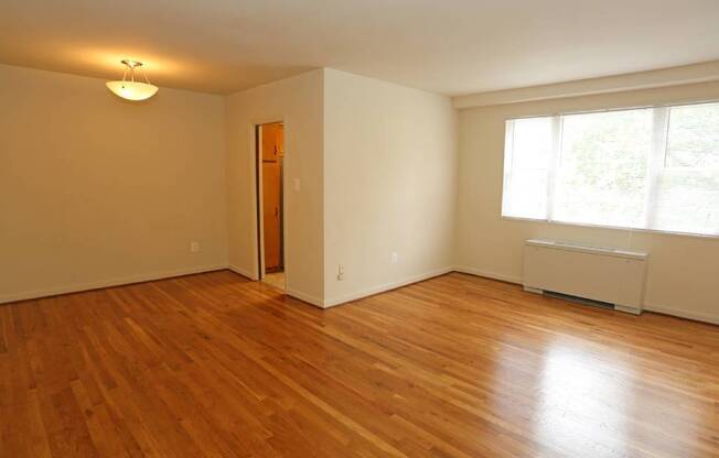 A room with wooden floors and a window Battery lane apartments in Bethesda maryland.