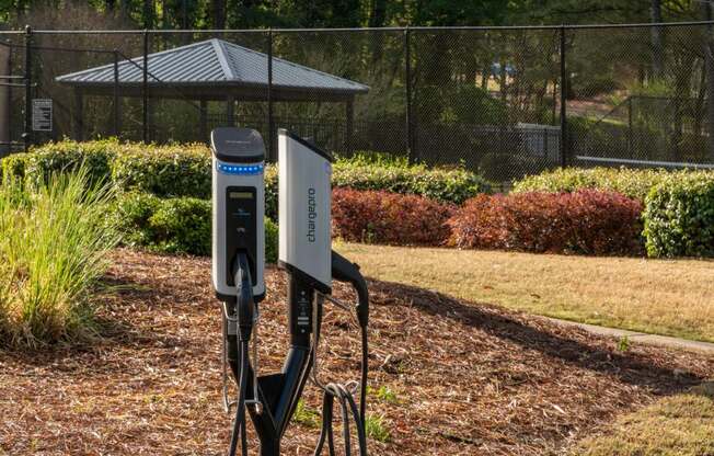 Veridian at Sandy Springs apartments power station in a park with a fence and a gazebo in the background