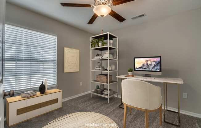 an office with a computer and a desk with a chair