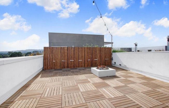 a roof terrace with wooden tiles and a wooden privacy fence