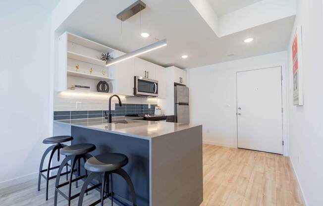 A kitchen with a bar stool and a counter.