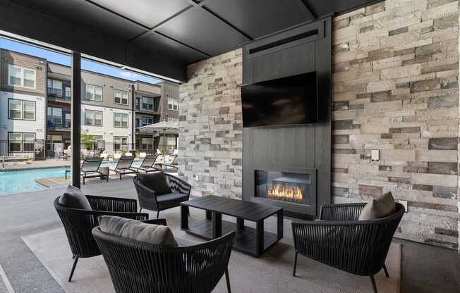 A modern outdoor seating area with a stone fireplace.