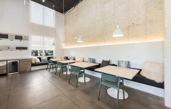 a dining room with tables and chairs and a kitchen