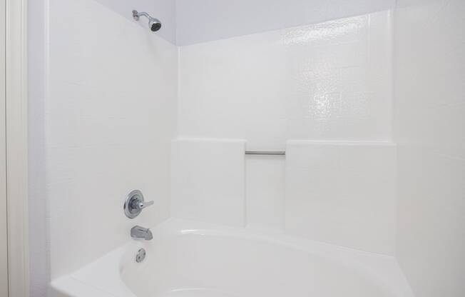 a white bathroom with a shower and a sink