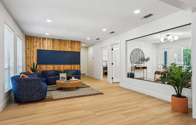 A living room with a blue chair and a wooden wall.