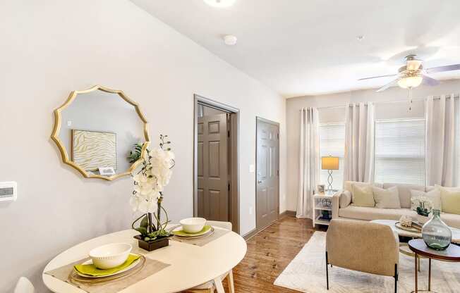 a living room with a dining room table and a ceiling fan