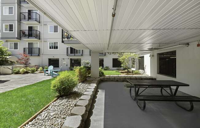 a covered patio with a picnic table and chairs at King Arthurs Court, Seattle