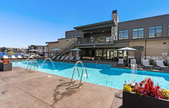 a swimming pool with chairs and a building in the background