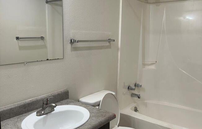 A white toilet sits next to a sink in a bathroom.