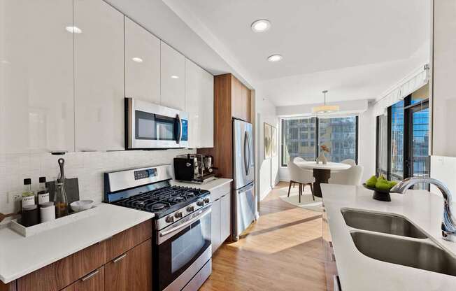 A modern kitchen with a stove, sink, and refrigerator.
