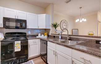 a kitchen with white cabinets and black appliances