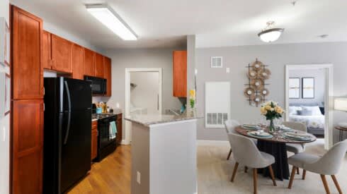 a kitchen and a dining room with a table and chairs