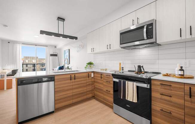 A modern kitchen with a stainless steel dishwasher and oven.
