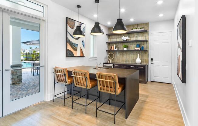 A stylish clubroom at Amavi Kissimmee offers inviting seating and a warm, modern design with effortless access to the pool just outside.