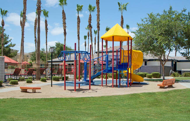 a playground with a yellow and blue slide and monkey bars