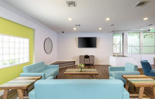 A living room with a blue couch and a flat screen TV.