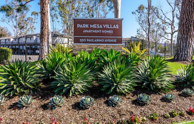 A sign for Park Mesa Villas Apartment Homes stands in front of a building.
