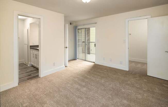A bedroom with a carpeted floor and a staircase leading to another room.