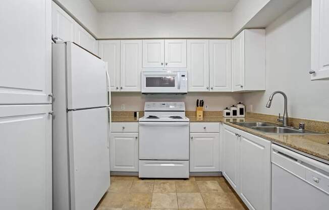 A kitchen with white appliances and cabinets. at Towers at Costa Verde Apartments, San Diego, CA