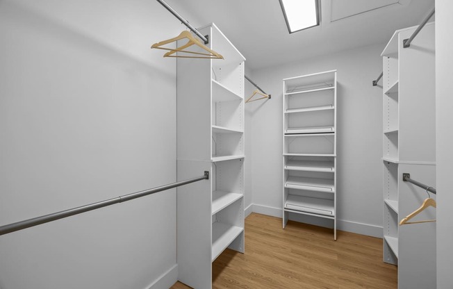 A walk in closet with shelves and hangers.