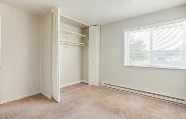 a bedroom with a large window and a closet