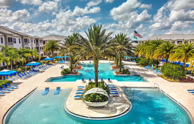 a large swimming pool with a fountain in the middle and a hotel in the background