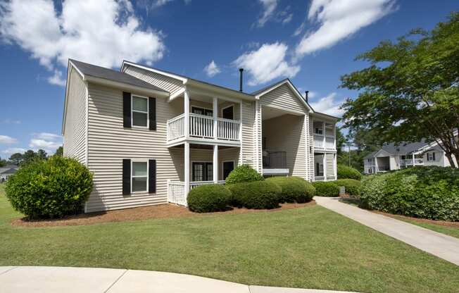 the view of an apartment building with a lawn and trees
