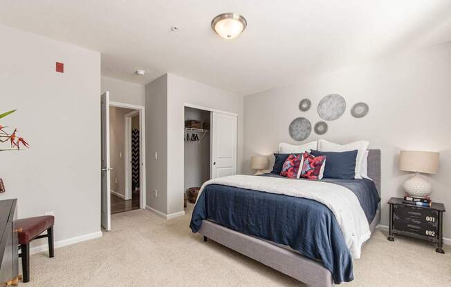 A bedroom with a bed, nightstands, and a chair.